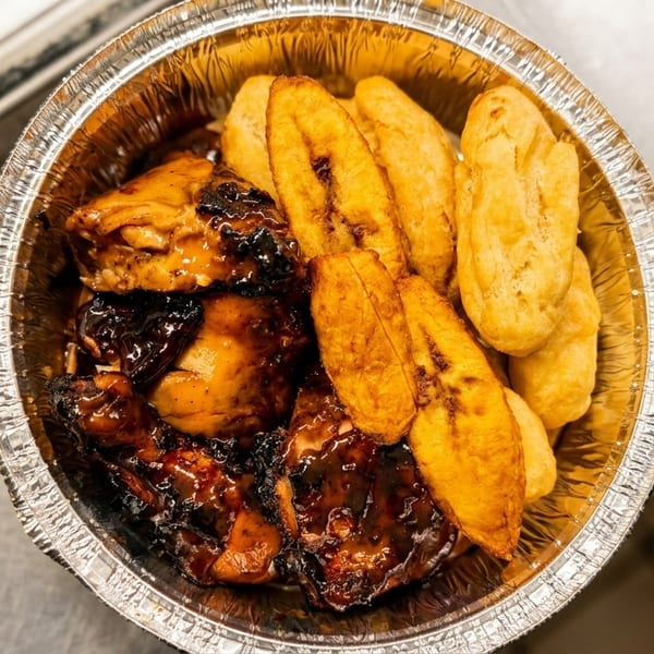 Takeout container filled with jerk chicken, fried plantains, and golden fried dumplings.